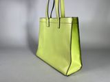 a lime green leather tote bag with black handles