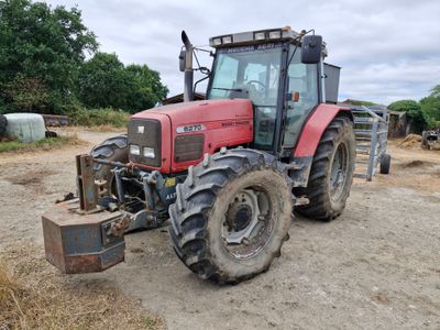 a red tractor that is parked in the dirt