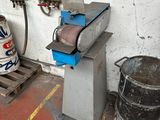 a machine that is sitting on a pallet next to a barrel