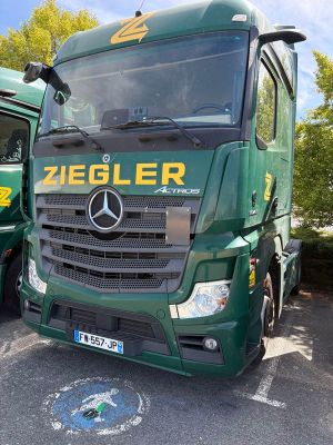 deux camions verts garés l'un à côté de l'autre sur un parking