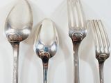 three spoons and a fork on a white table
