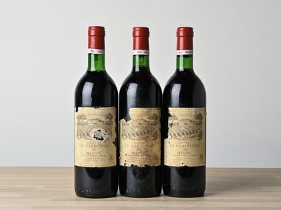 trois bouteilles de vin posées sur une table en bois