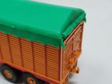 a toy truck with a green roof on a white surface