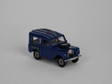 un petit camion bleu posé sur une surface blanche