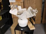 a vase with flowers in it sitting on a shelf