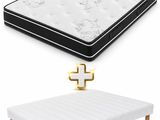 a white mattress and a black and white bed with a gold cross on it