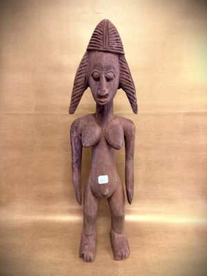 statue of a woman with a hat on her head on a wooden surface