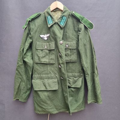 an army green jacket with a white bird on the chest and a green collar