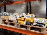many bags of cement sitting on pallets in a warehouse
