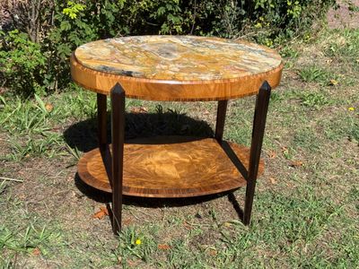 a small table with a marble top in the grass