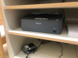 a printer that is sitting on a shelf in a closet