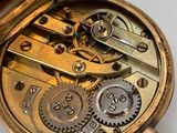 a close up of a pocket watch on a white surface