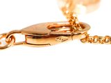 a close up of a gold chain with a heart on it