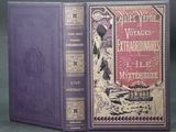 an old book with a purple cover sitting on top of a table
