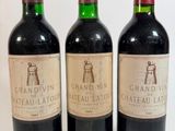 trois bouteilles de vin sont alignées sur une surface blanche