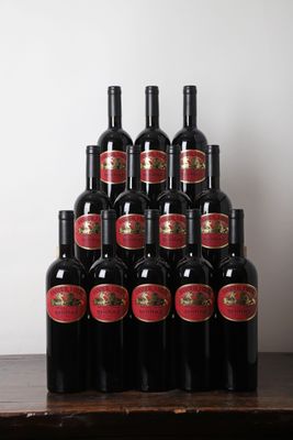 Plusieurs bouteilles de vin rouge sont posées sur une table devant un mur blanc.