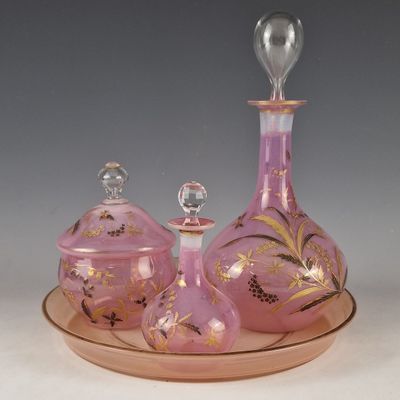 un service en verre rose orné d'un motif à la feuille d'or