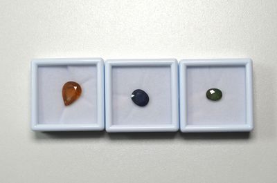 trois pierres de couleurs différentes posées dans une boîte blanche