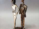 statue of a man and a woman holding hands on a white surface
