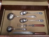 a lot of spoons and spoon knives in a box