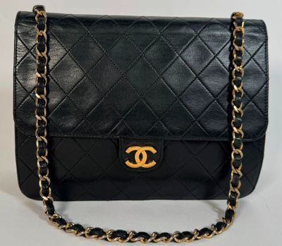 un sac Chanel noir avec des finitions dorées et une chaîne