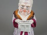 une vieille figurine représentant un homme tenant un journal dans ses mains