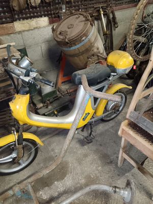 a yellow scooter that is parked in a garage