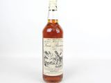 un gros plan d'une bouteille de whisky posée sur une surface blanche