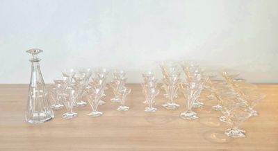 des bouteilles et des verres posés sur une table en bois, avec un vase en arrière-plan