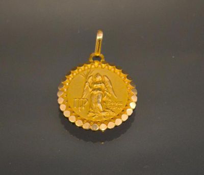 a gold pendant with a picture of the virgin and child on it