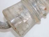a small glass jar with a handle on a hook