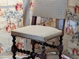 a chair that is sitting in front of a wallpapered wall
