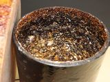 a metal cup with a mixture in it sitting on a table