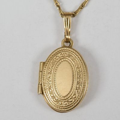 un collier « Locke » en or, orné d'un petit pendentif ovale « Locke » suspendu à une chaîne