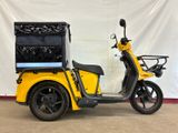 an image of a yellow scooter parked in front of a white wall