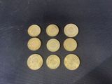 six gold coins are arranged in a row on a black surface