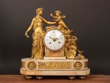une horloge en or surmontée d'une statue