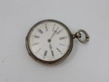 a silver pocket watch with roman numerals on the face