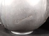 a close up of a silver vase on a black surface