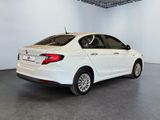 the back end of a white car in a room with a gray floor