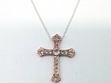 un gros plan d'un collier orné d'une croix sur fond blanc