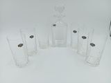 six verres et une carafe posés sur une table
