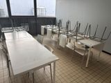tables and chairs are lined up in a room with a large window