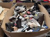 plusieurs paires de chaussures dans une boîte en carton posée sur le sol