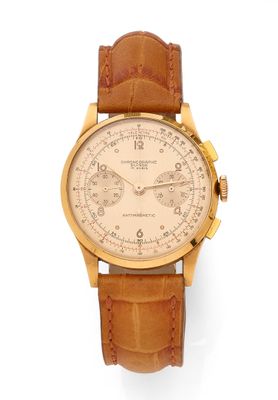 a close up of a watch on a white surface with a brown strap