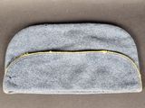 un petit sac gris muni d'une fermeture éclair sur le dessus