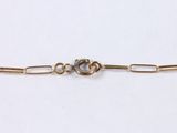 a close up of a gold chain with a knot on it
