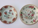 deux assiettes ornées de fleurs et d'oiseaux, posées sur une table