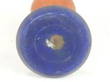 a blue and orange candle sitting on a white surface