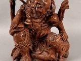 une image représentant une statue en bois d'un homme tenant un poisson